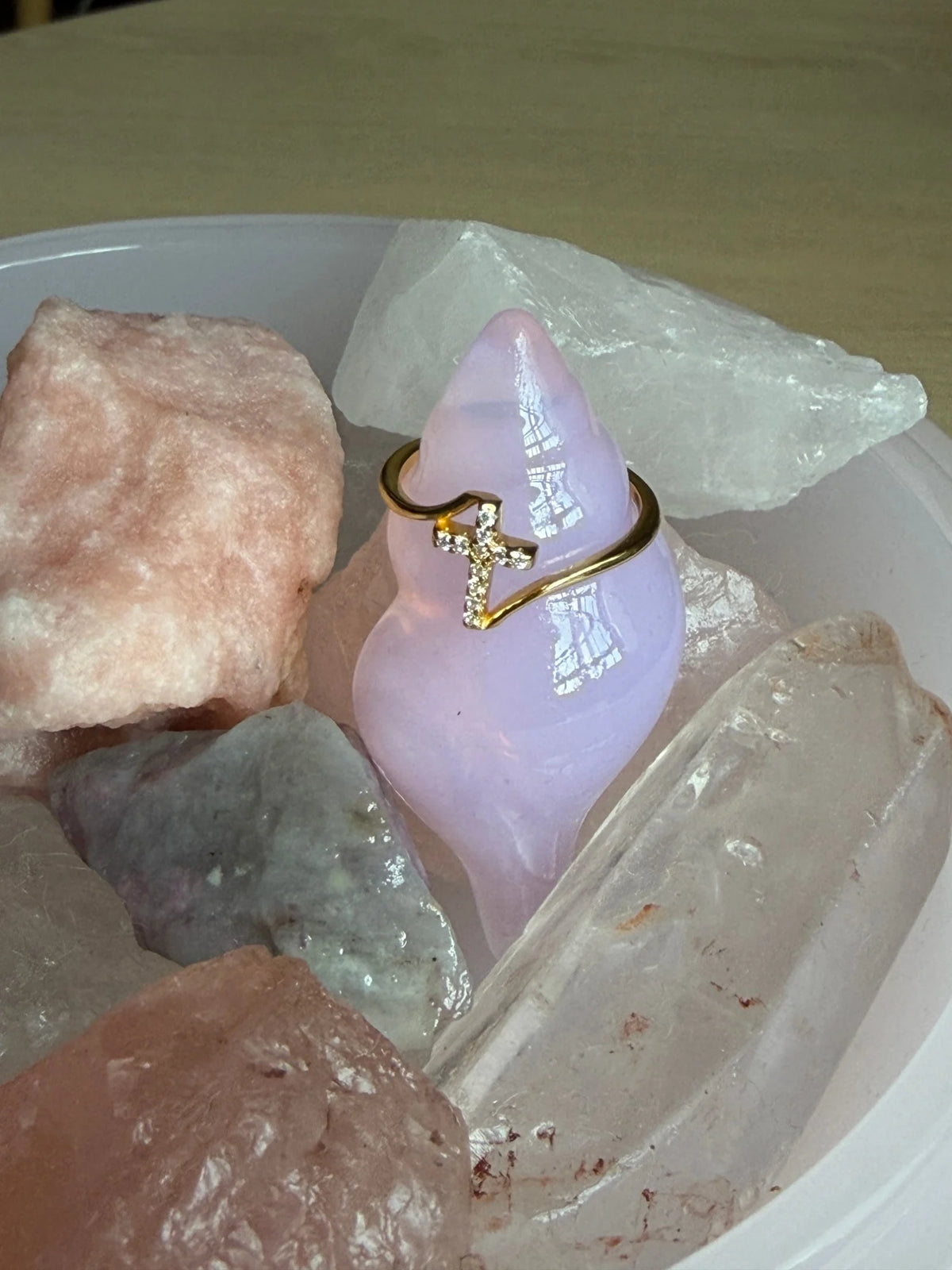 Gold cross ring with CZ stones styled on a lavender stone with rose quartz crystals
