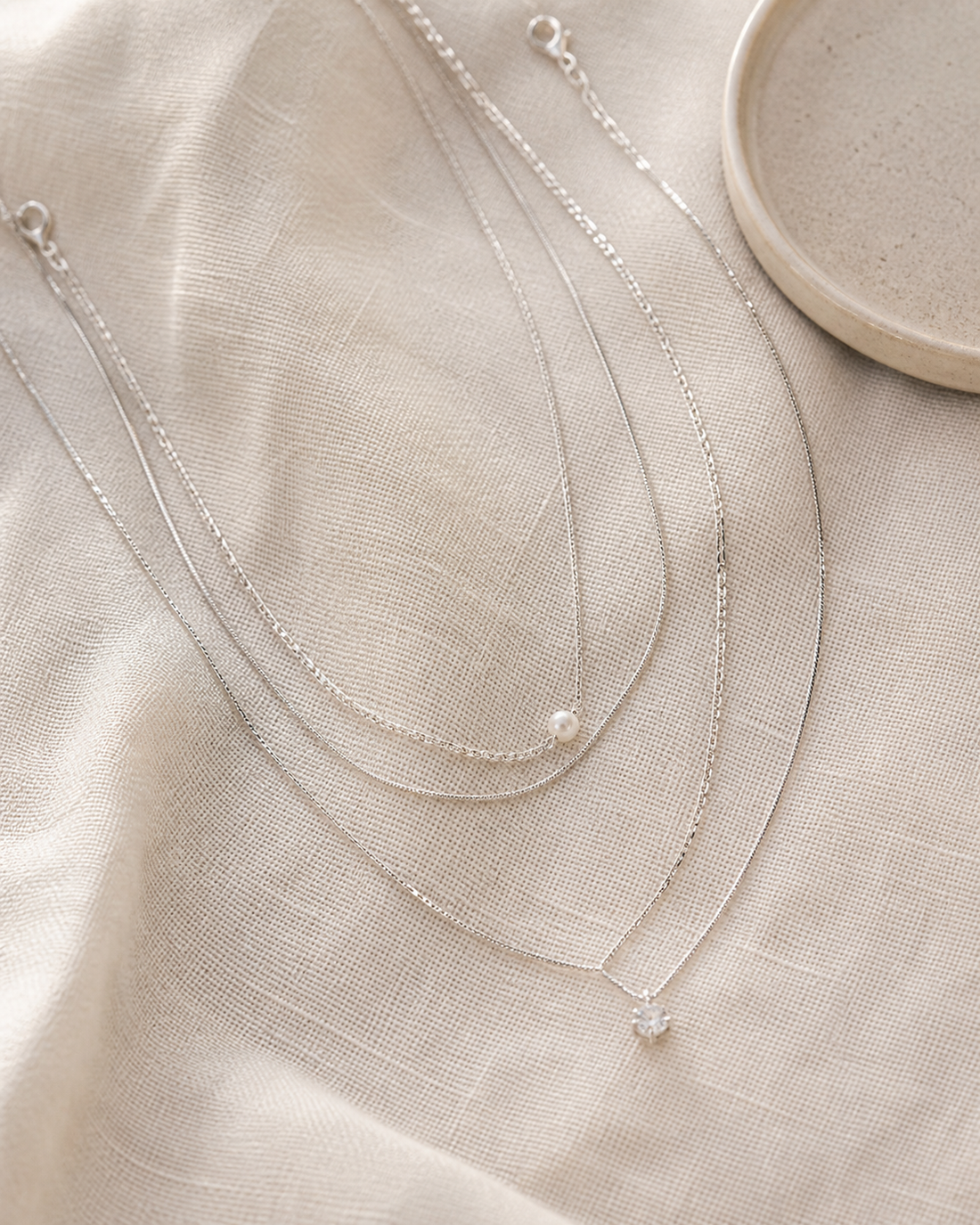 Three delicate necklaces arranged for a layered look