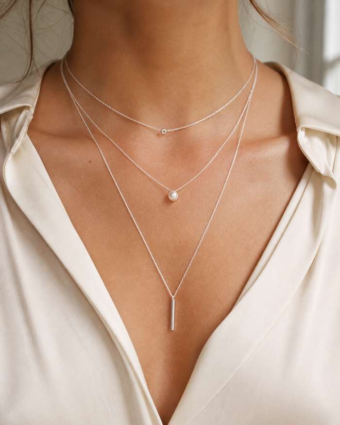 Three sterling silver necklaces worn at different lengths