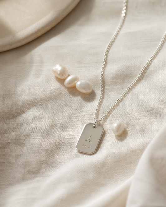 Personalized sterling silver necklace with pearls on ivory linen