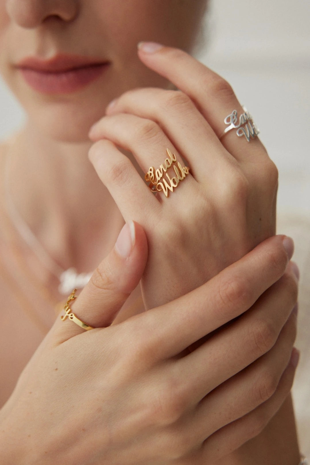 Model wearing gold and silver personalized name rings