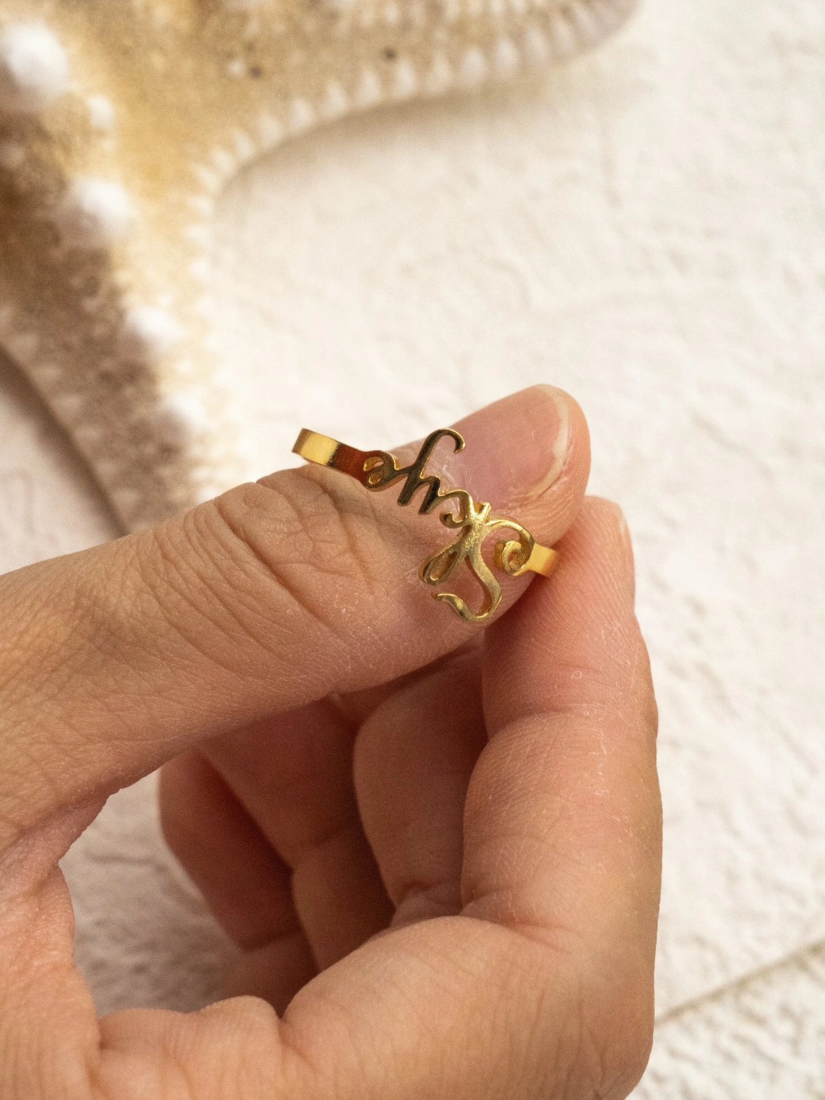 Close-up of gold Skye cutout lettering and ring band