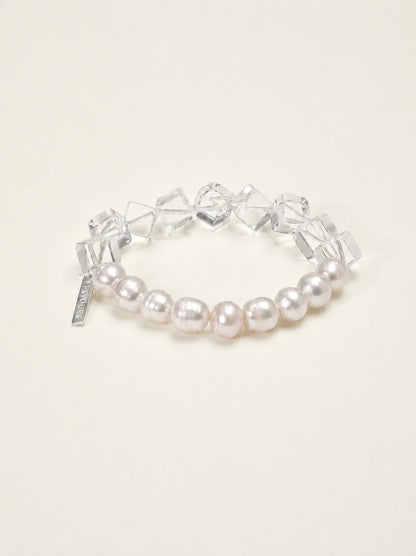Freshwater pearl and geometric clear quartz bracelet on warm ivory background
