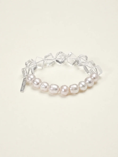 Freshwater pearl and geometric clear quartz bracelet on warm ivory background
