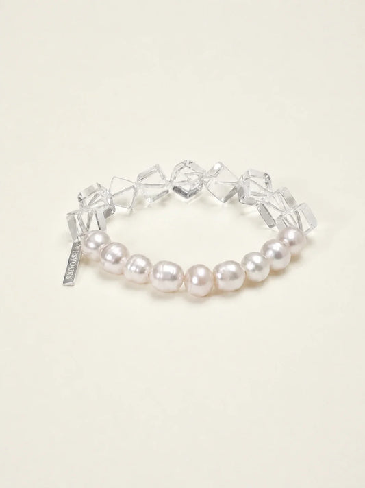 Freshwater pearl and geometric clear quartz bracelet on warm ivory background