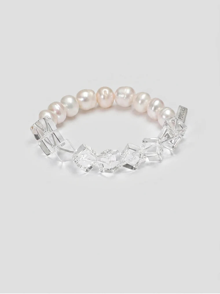 Clear quartz and freshwater pearl side of the bracelet on a gray background