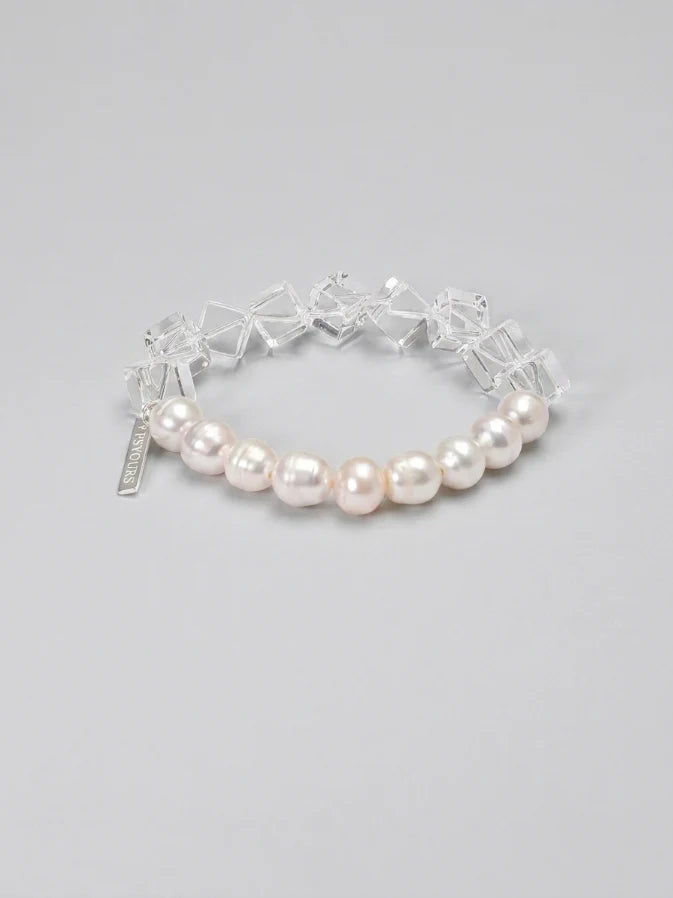 Freshwater pearl and geometric clear quartz bracelet on a gray background