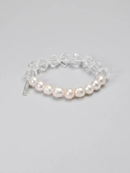 Freshwater pearl and geometric clear quartz bracelet on a gray background