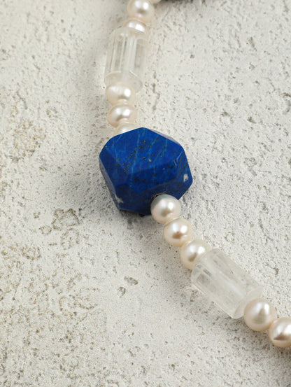 Close-up of lapis lazuli, clear gemstone beads, and freshwater pearls