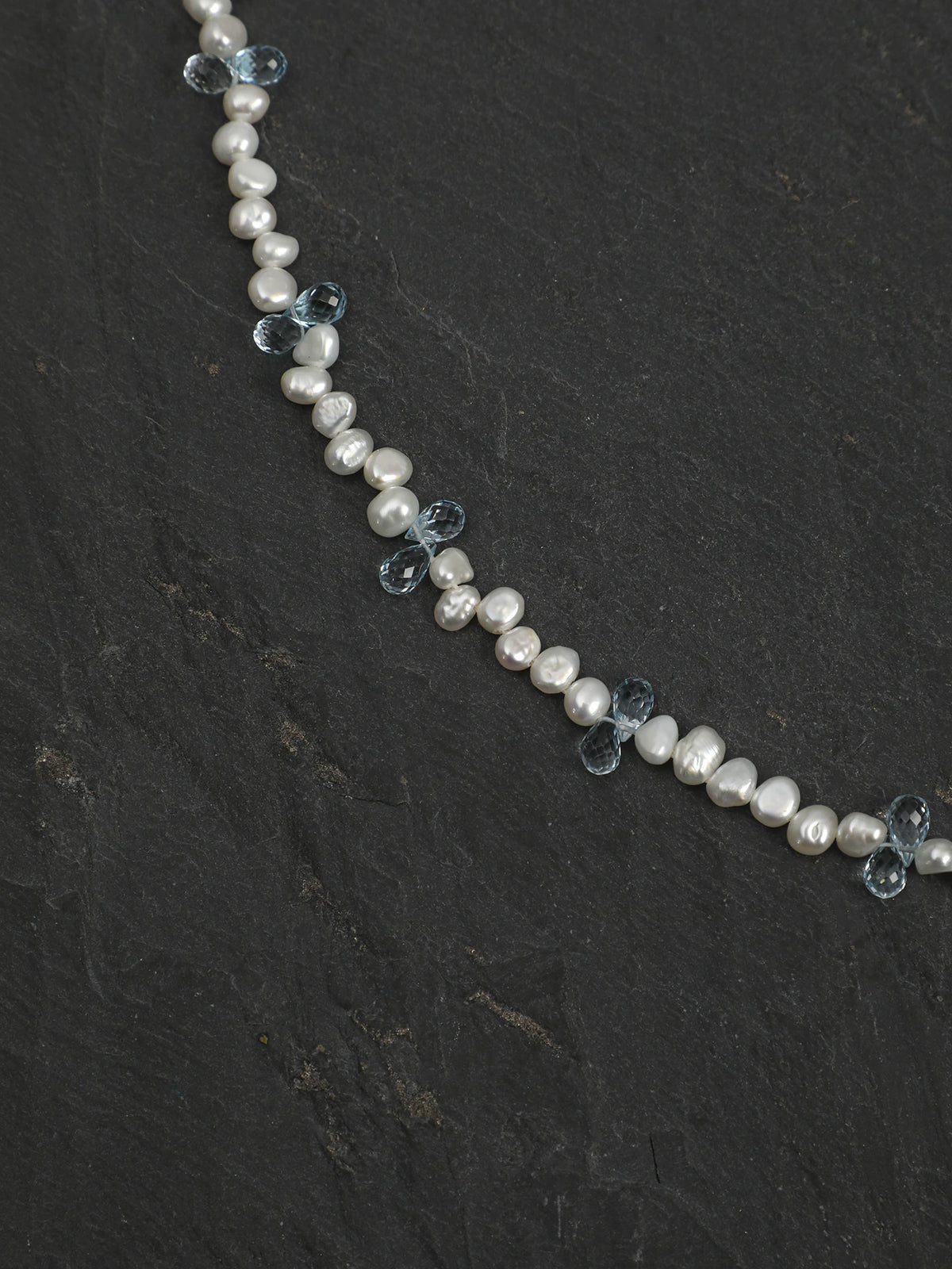 Close-up of baroque pearls and blue topaz drops