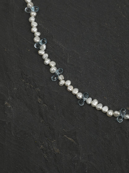 Close-up of baroque pearls and blue topaz drops