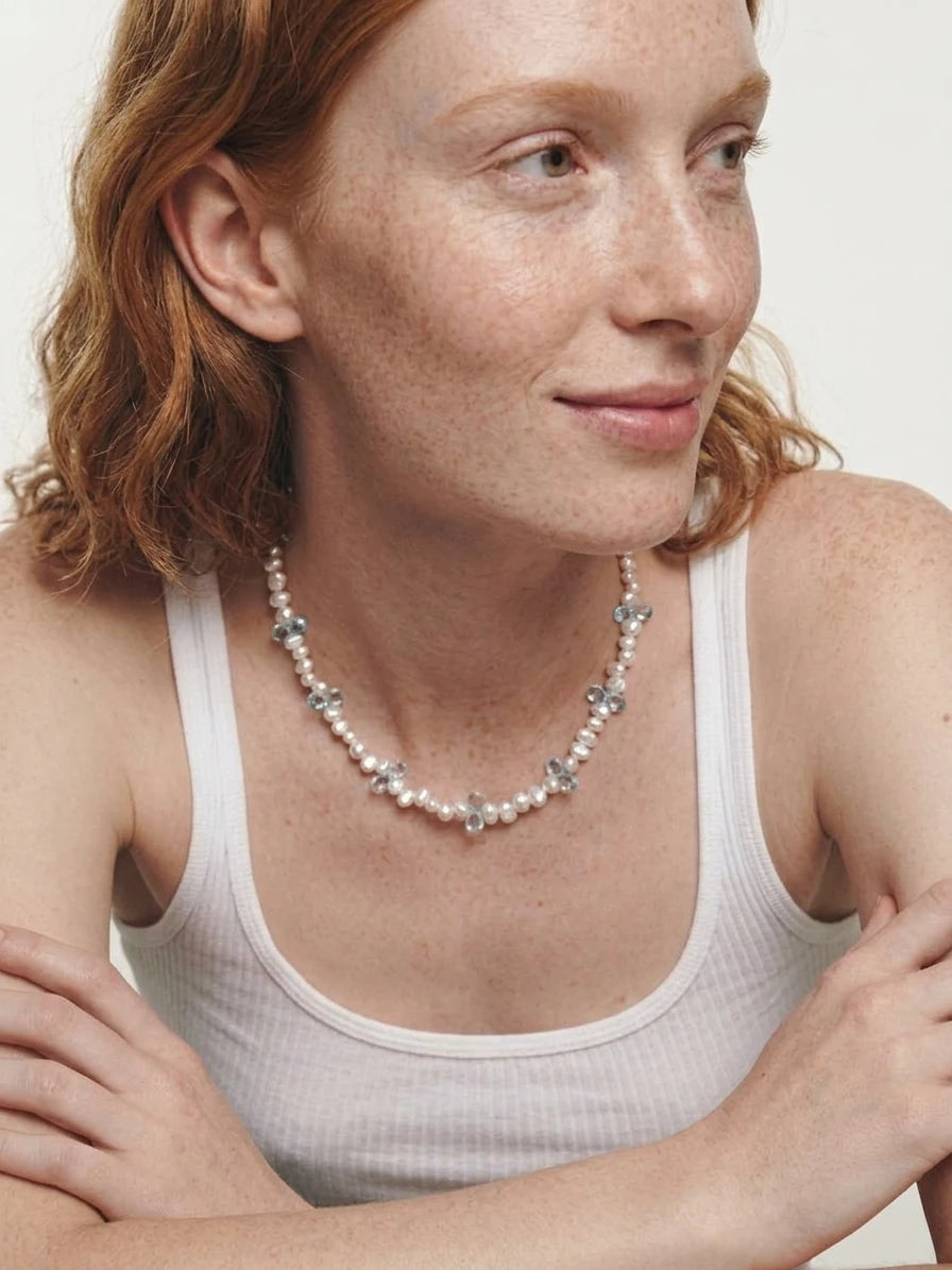 Close-up styling reference of the pearl and blue topaz necklace