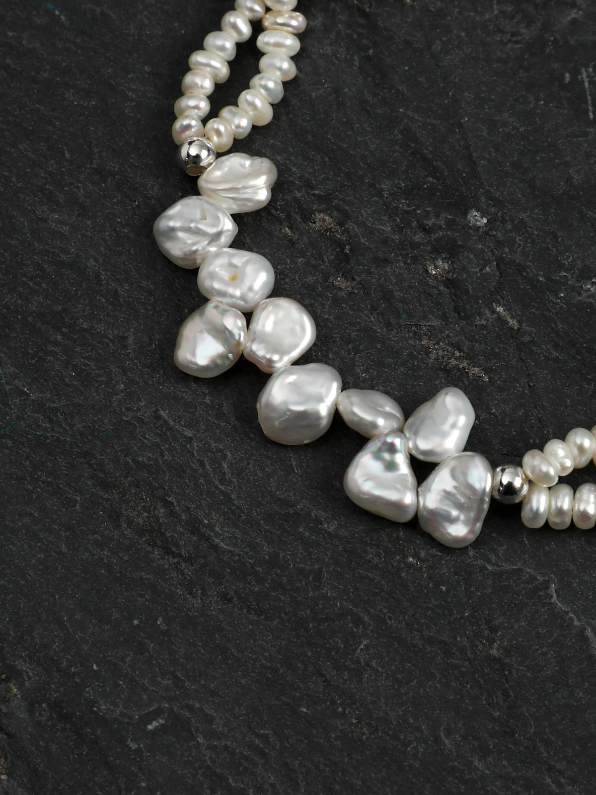 Close-up of the 925 silver spacer beads, clasp, and engravable round tag