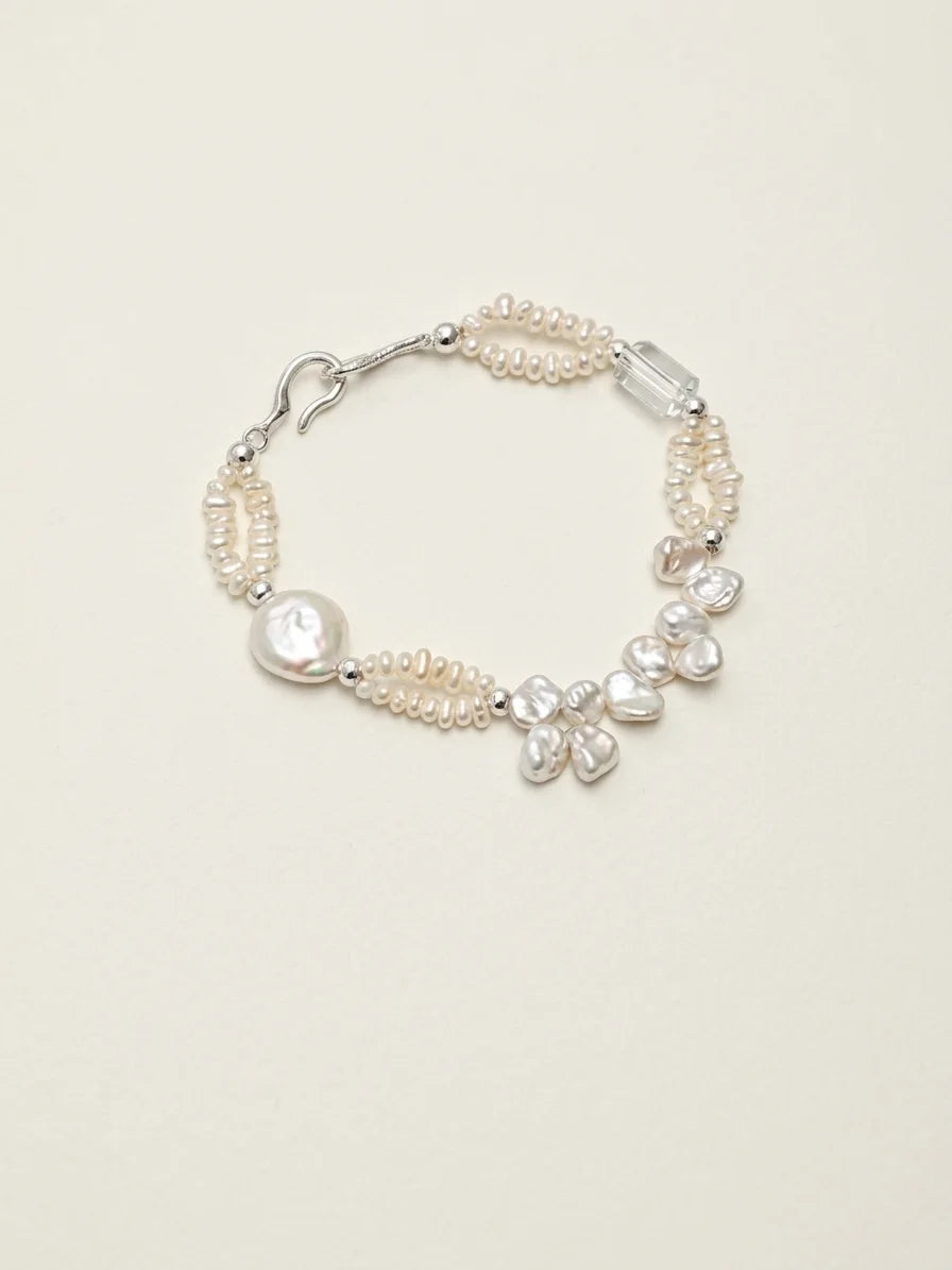 Crashing Waves baroque pearl and clear quartz bracelet on a light background