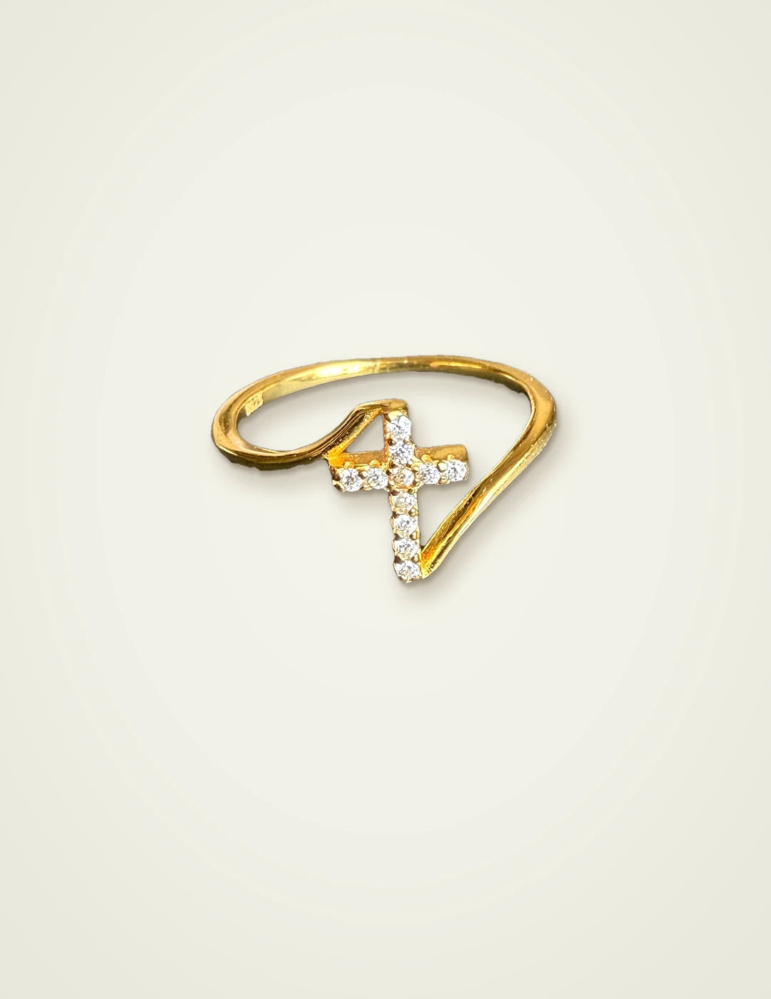 Dainty cross ring in 14K gold plated 925 sterling silver with CZ stones on a cream background