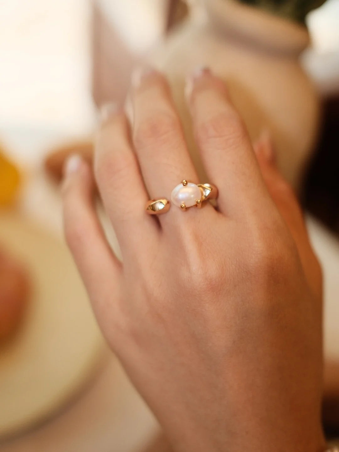 Model wearing the Faceted Pearl Claw Open Ring in gold