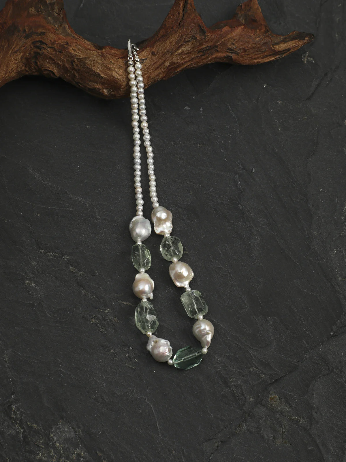 Green quartz and baroque pearl necklace with sterling silver hook clasp draped on driftwood