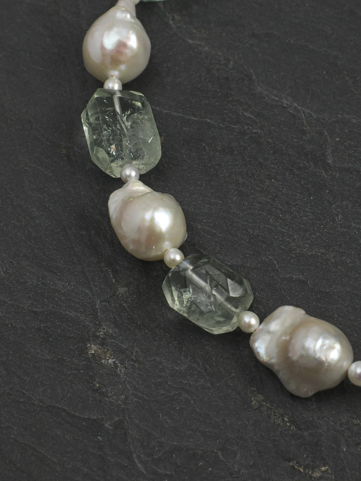 Close-up of freeform natural green quartz and large baroque pearls