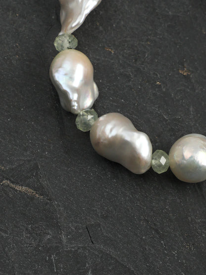 Psyours Misty Green bracelet styled on driftwood, showing the sterling silver logo tag