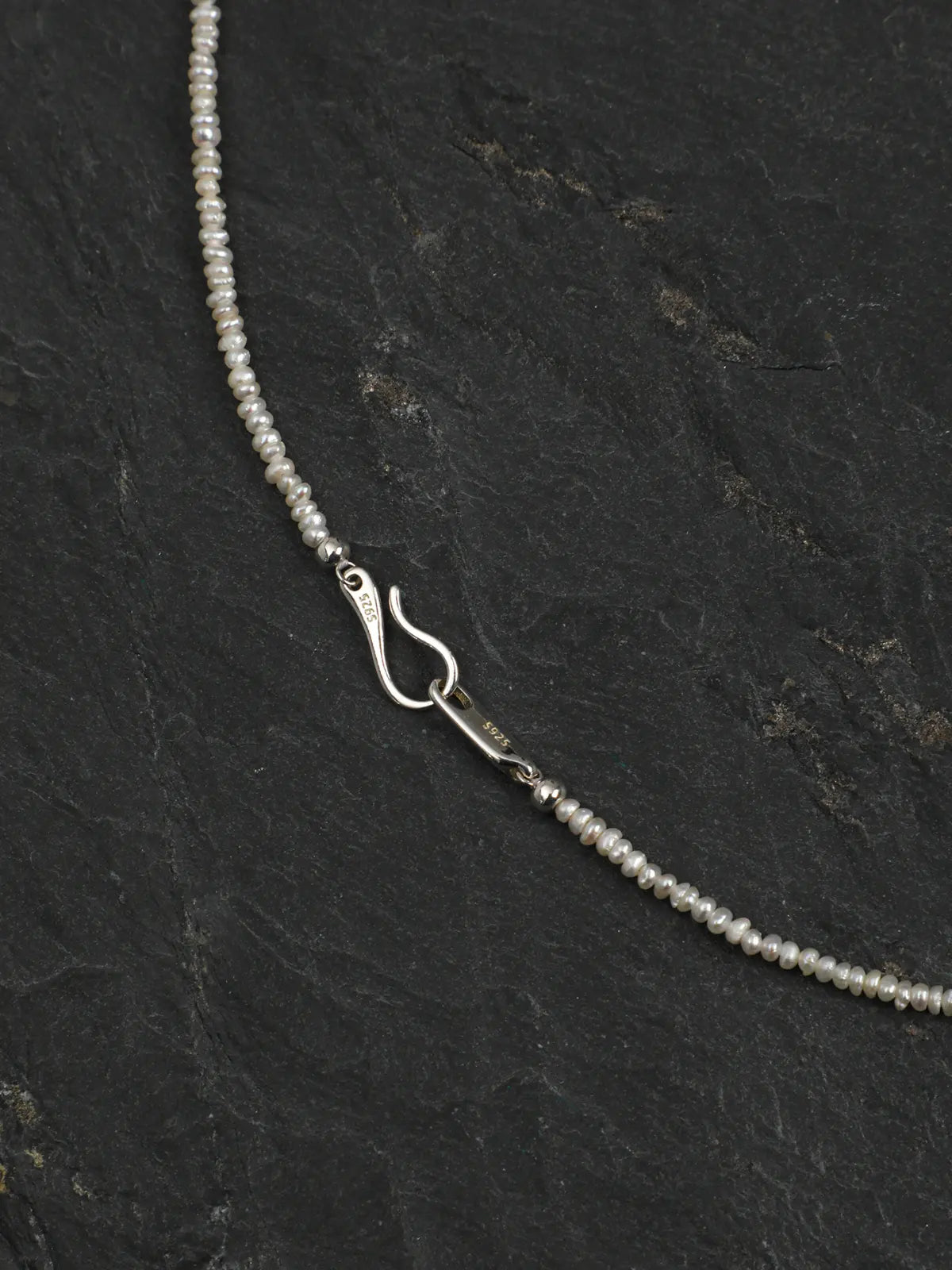 Close-up of the silver hook clasp and small pearl strand