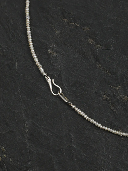 Close-up of the silver hook clasp and small pearl strand