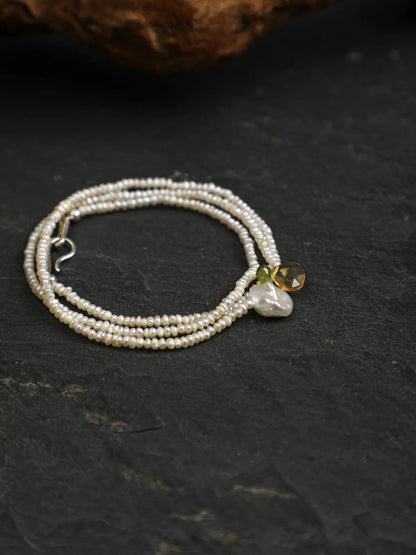 Coiled pearl necklace showing the clasp and gemstone accents