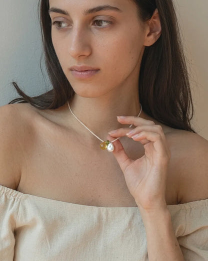 Illustrative styling portrait showing the pearl necklace