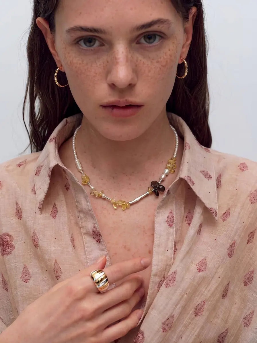 Styling illustration of the Golden Sunlight necklace worn with a patterned shirt; other jewelry is not included