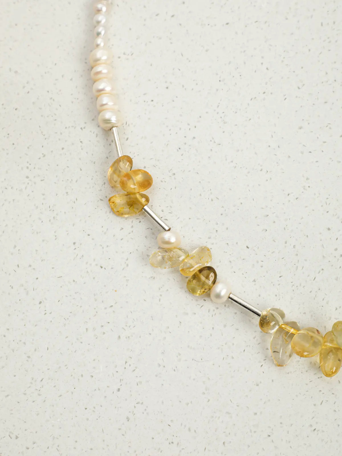 Close-up of citrine chips, pearls and silver tube spacers