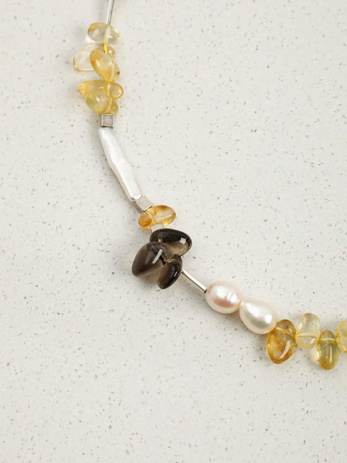Smoky quartz, citrine and pearls beside a polished silver spacer