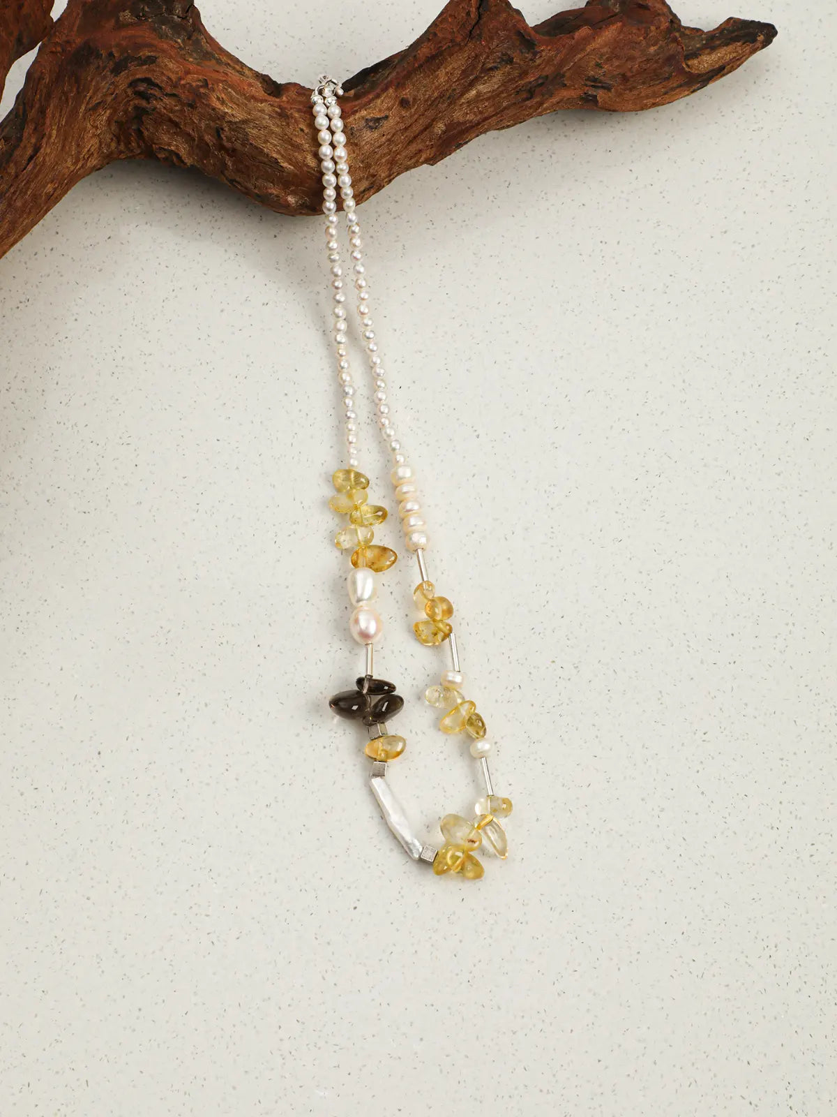 Golden Sunlight pearl and gemstone necklace draped over wood
