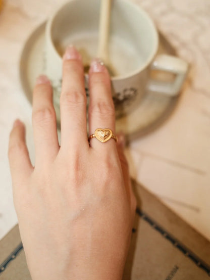 Close-up of the Vintage Textured Heart Open Ring in gold on the hand