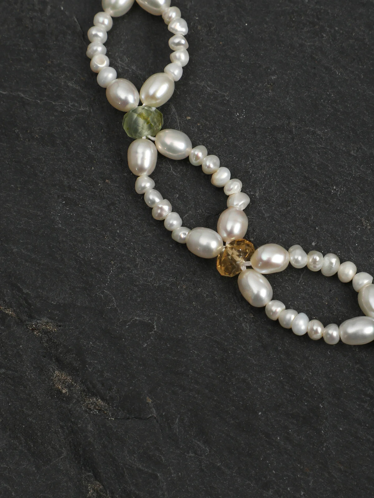 Woven Waves pearl lace bracelet with vibrant gemstone accents on a light background