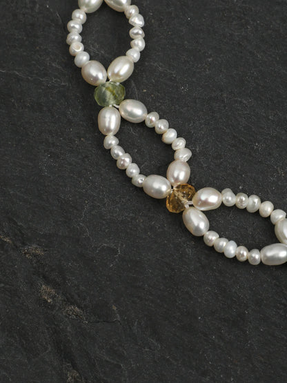 Woven Waves pearl lace bracelet with vibrant gemstone accents on a light background