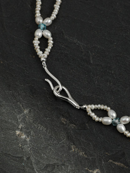 Woven Waves pearl lace necklace with multi-gemstone accents on a light background