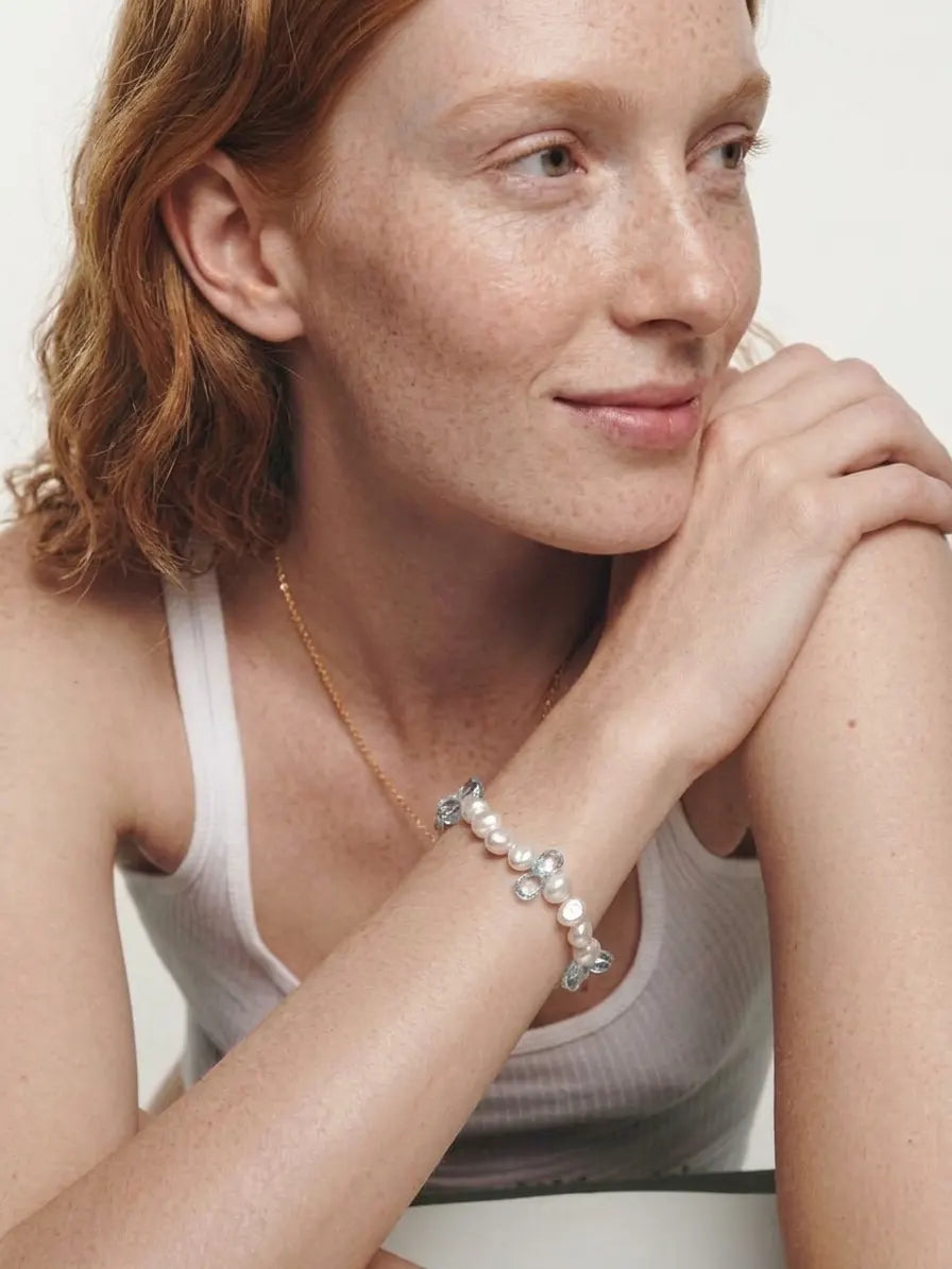 Model wearing a baroque pearl and blue topaz bracelet